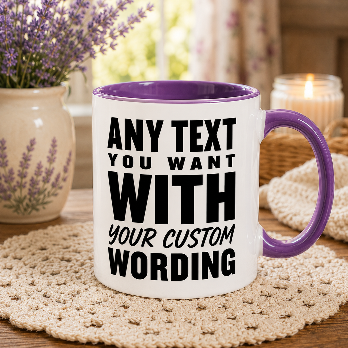 A white ceramic mug with a purple interior and handle, printed with ANY TEXT YOU WANT WITH YOUR CUSTOM WORDING' in bold black letters. The mug is set on a beige crocheted coaster on a wooden table, surrounded by a potted lavender, a lit candle, and a cozy blanket in a warm, softly blurred background.