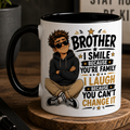 Mug with a brother-themed design on a wooden coaster with coffee beans and a book.