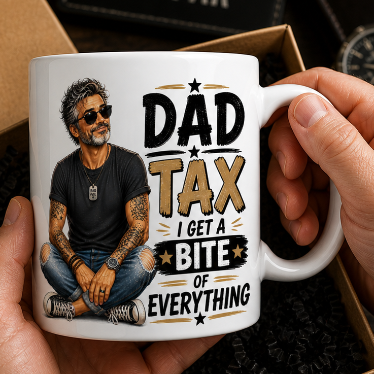 Person holding a mug with a dad-themed design, surrounded by gift boxes and items on a wooden surface.