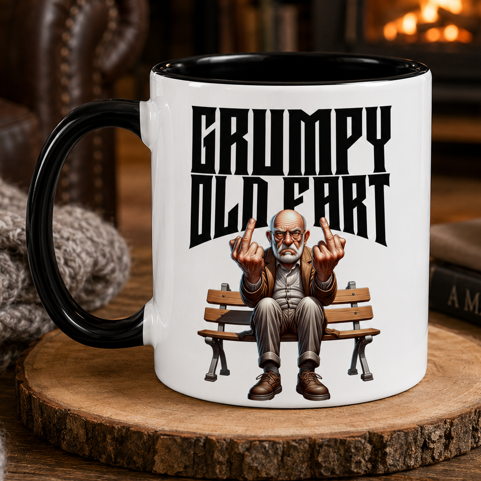 Mug with 'Grumpy Old Fart' design featuring a cartoon grumpy old man on a bench, placed on a wooden coaster.