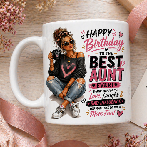 White mug with birthday message for the best aunt, surrounded by flowers and a gift box.