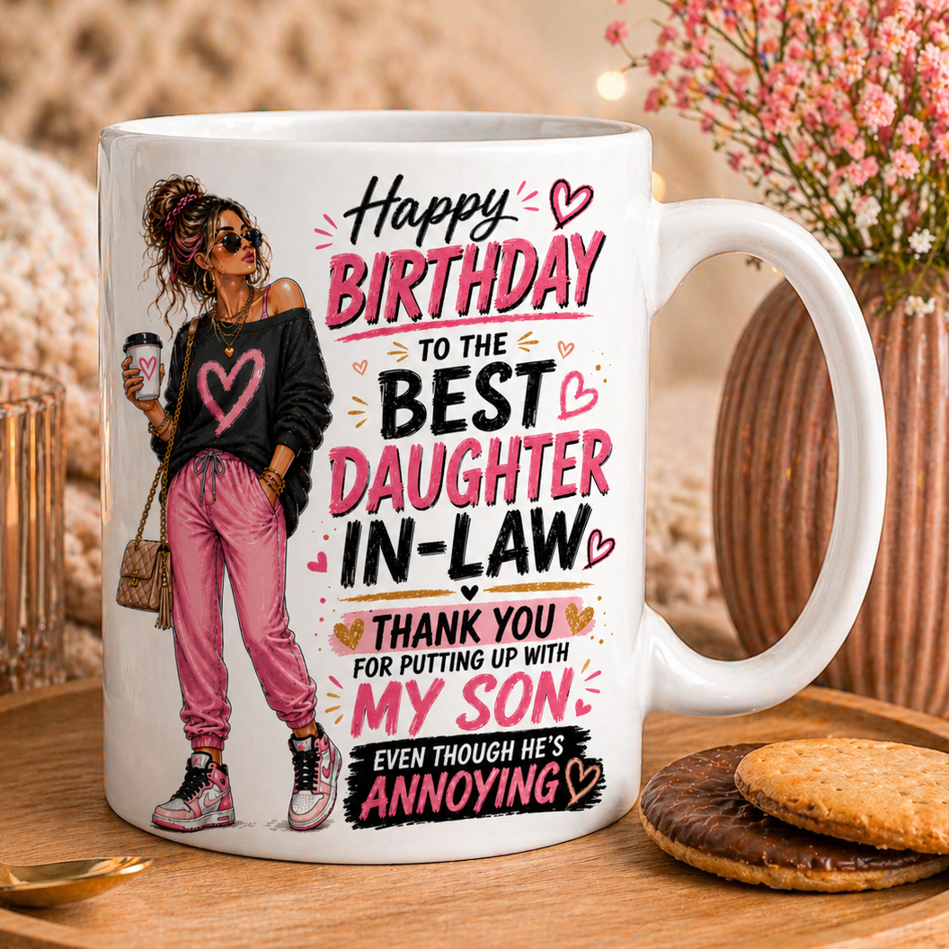 White mug with a design and text for a daughter-in-law on a wooden tray with cookies and flowers.