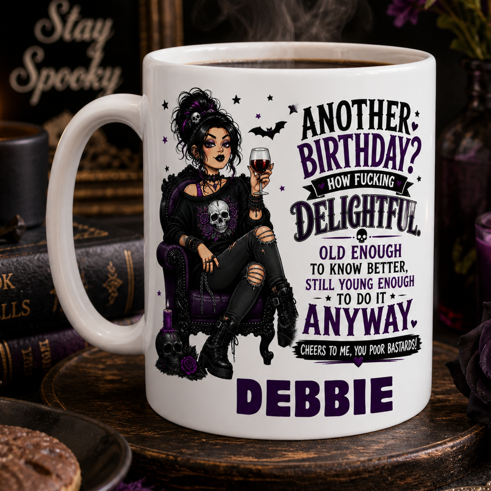 White mug with a witch design and text, surrounded by Halloween-themed decor.
